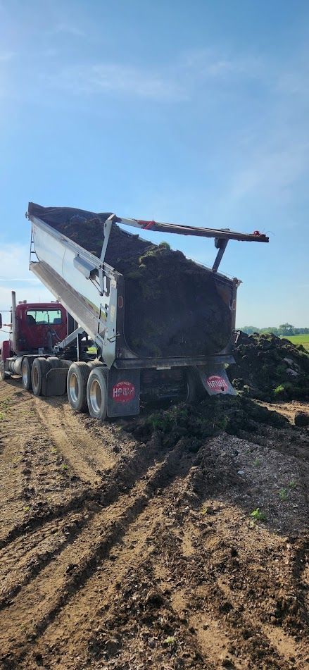 Flatbed truck hauling a heavy machine for construction