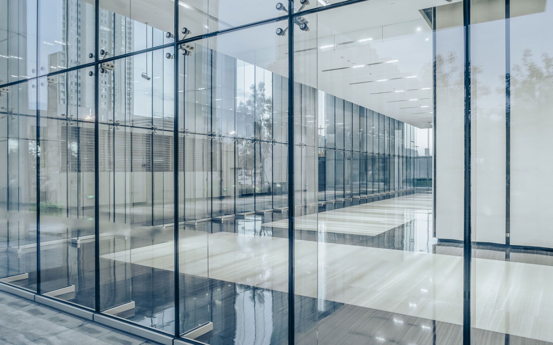 An empty office building with a lot of windows and a wooden floor.
