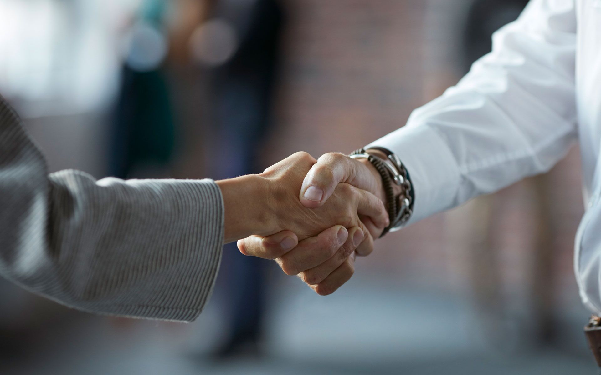 A man and a woman are shaking hands in an office.