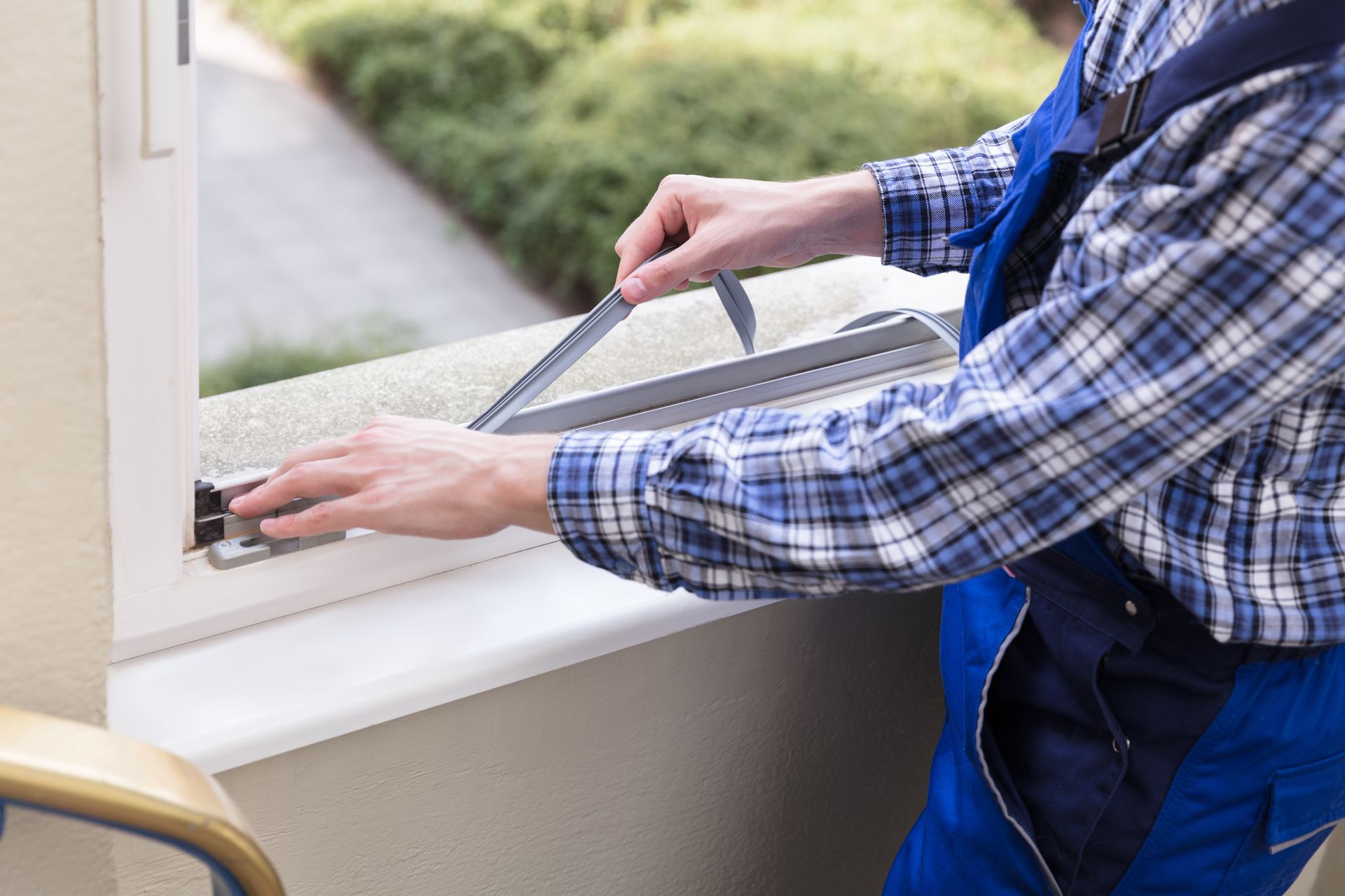 Technician replacing weatherstripping as part of window waterproofing