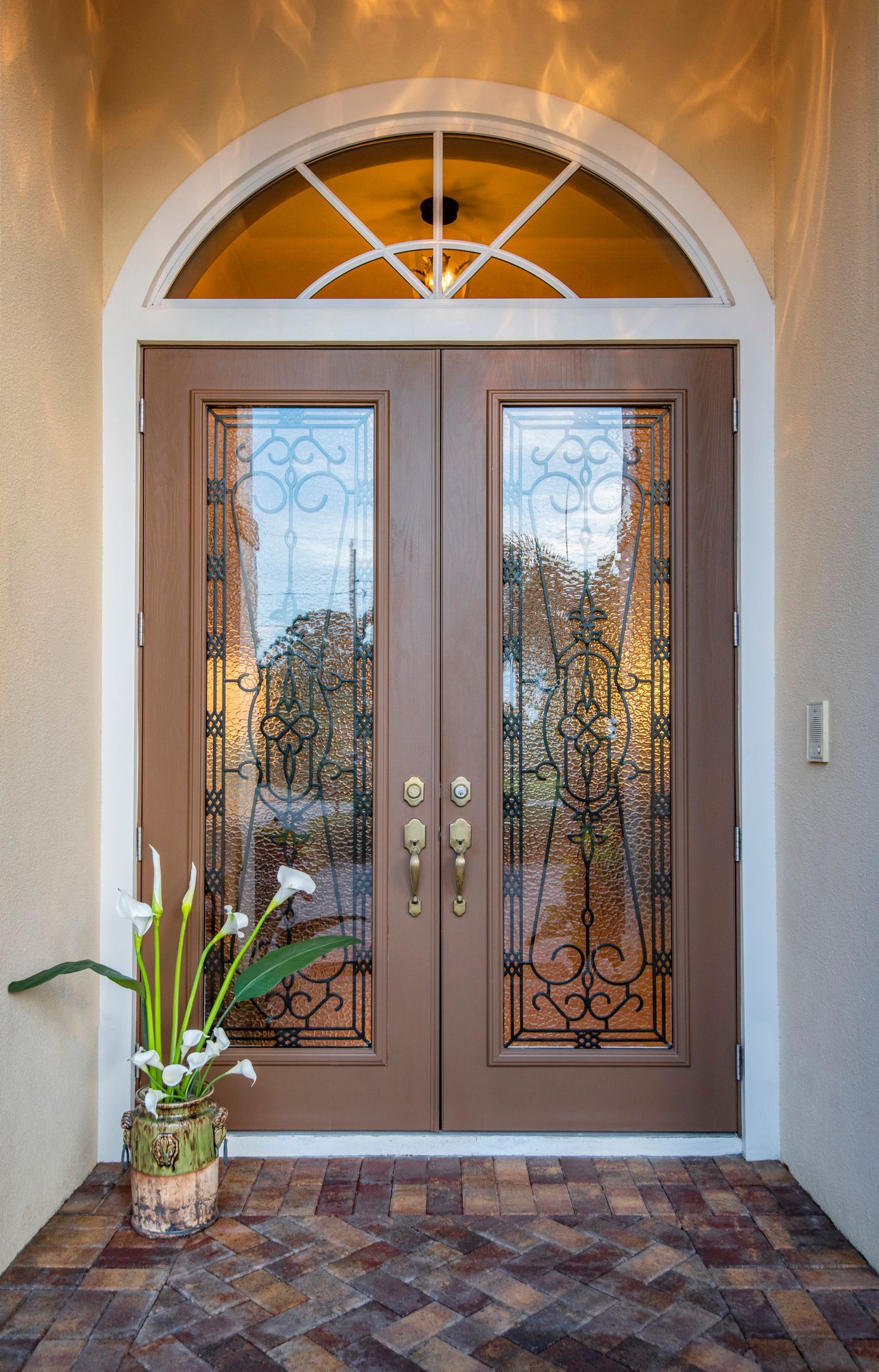 A front entry with a two door entrance, doors closed with an arched transom |  Window Doctor | Stuar