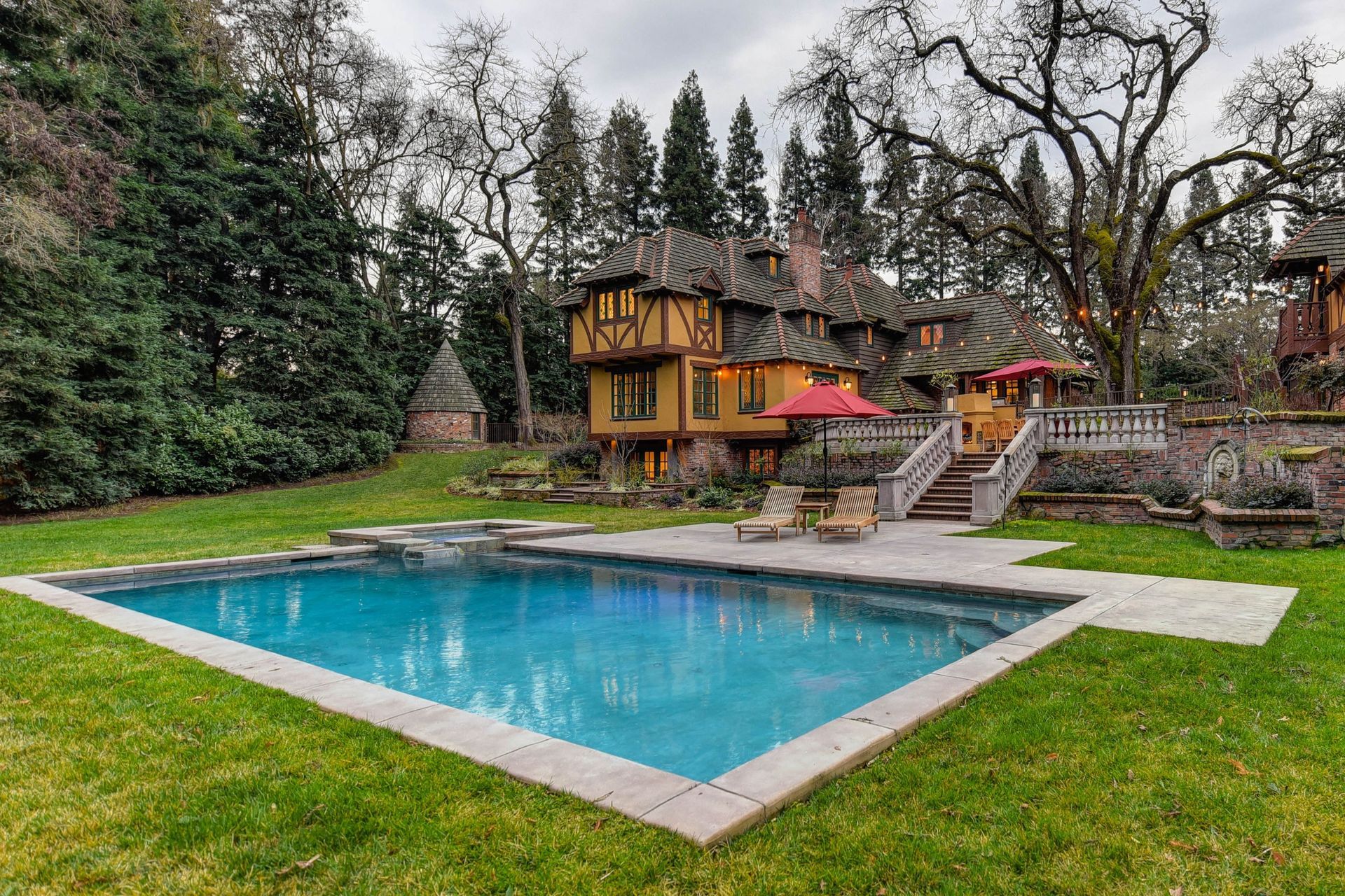European style house with stairs leading to backyard pool. 