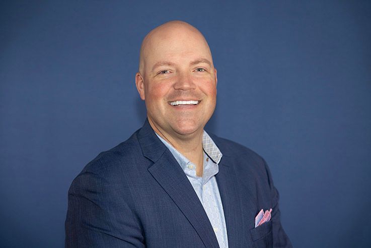 A man in a suit and tie is smiling for the camera.