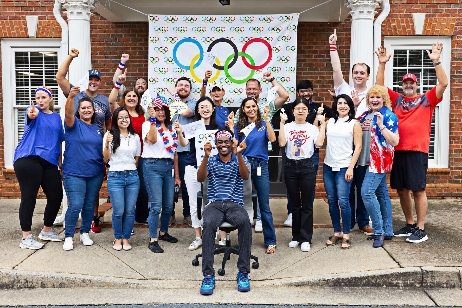 A group of people are posing for a picture in front of a building.