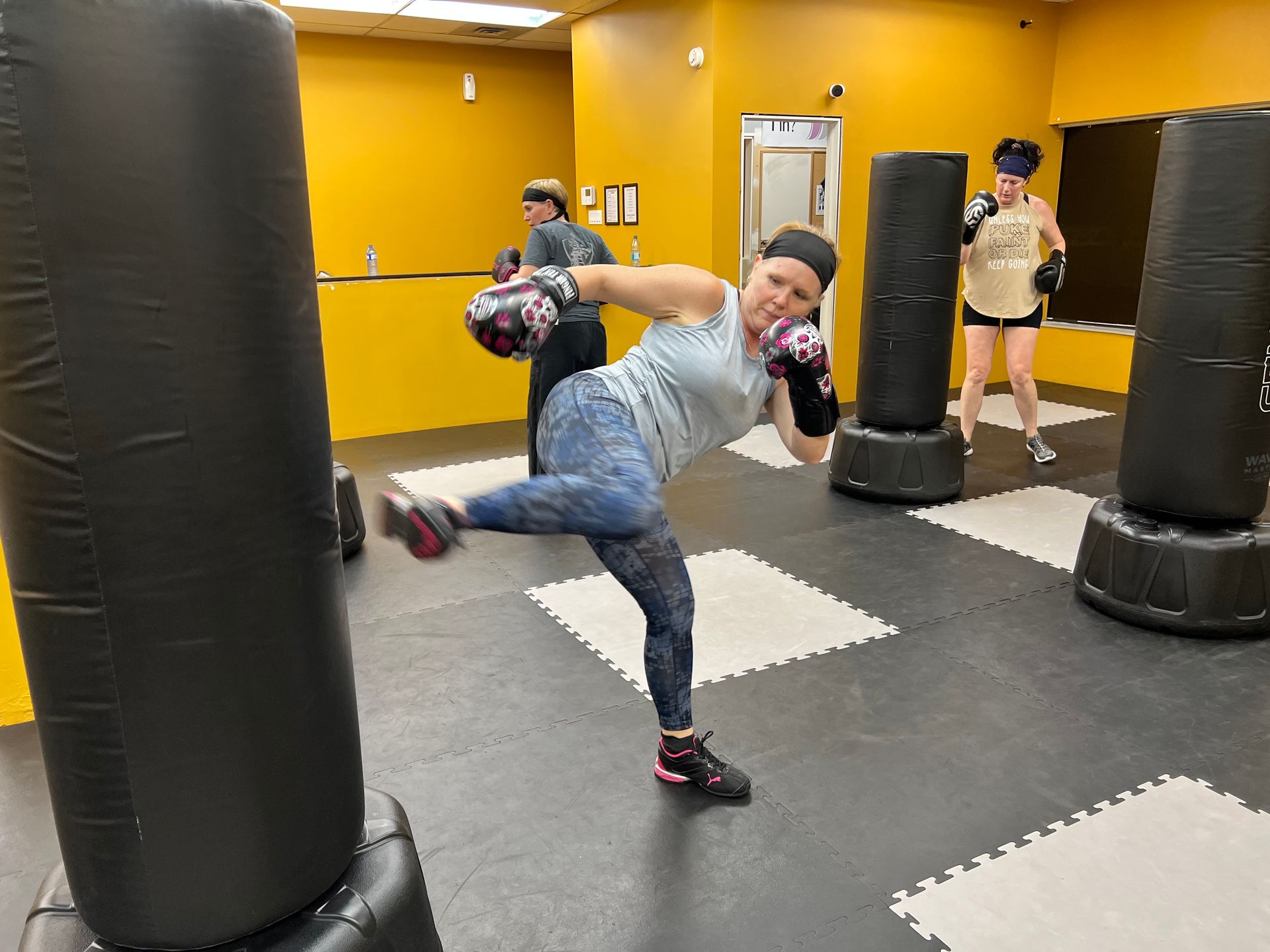 Group fitness kickboxing class training on heavy bags