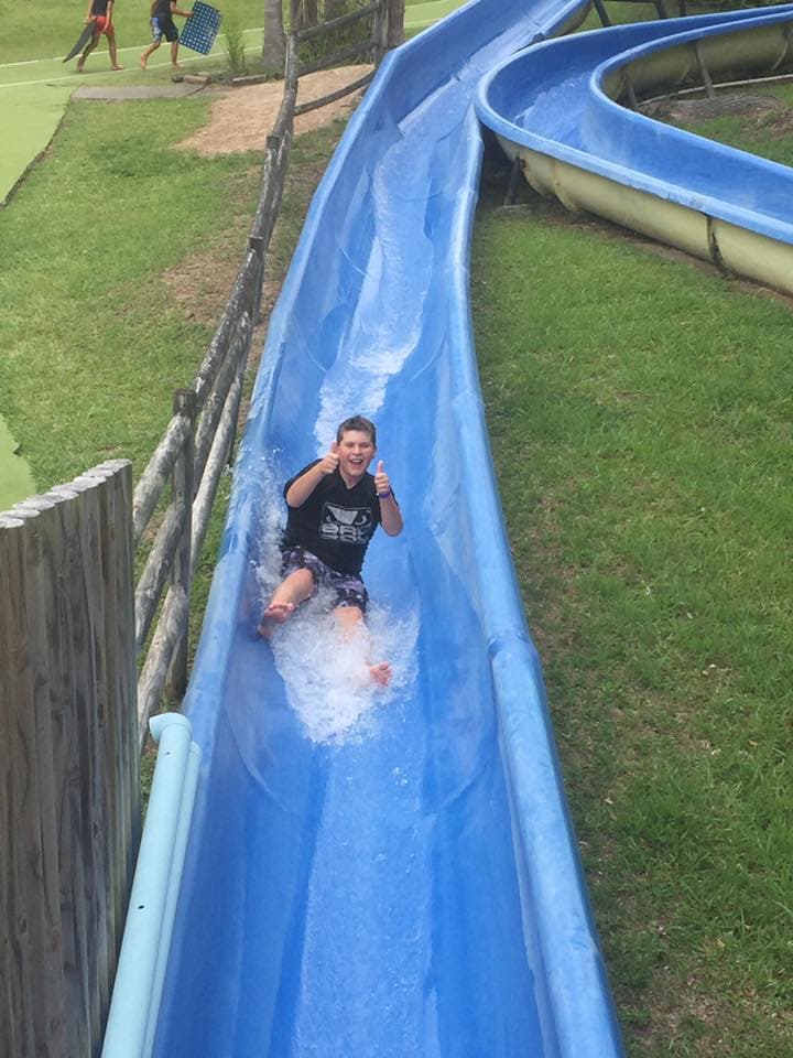 Boy Sliding in the Water Slide In The Big Buzz Fun Park in Rainbow Flat, NSW