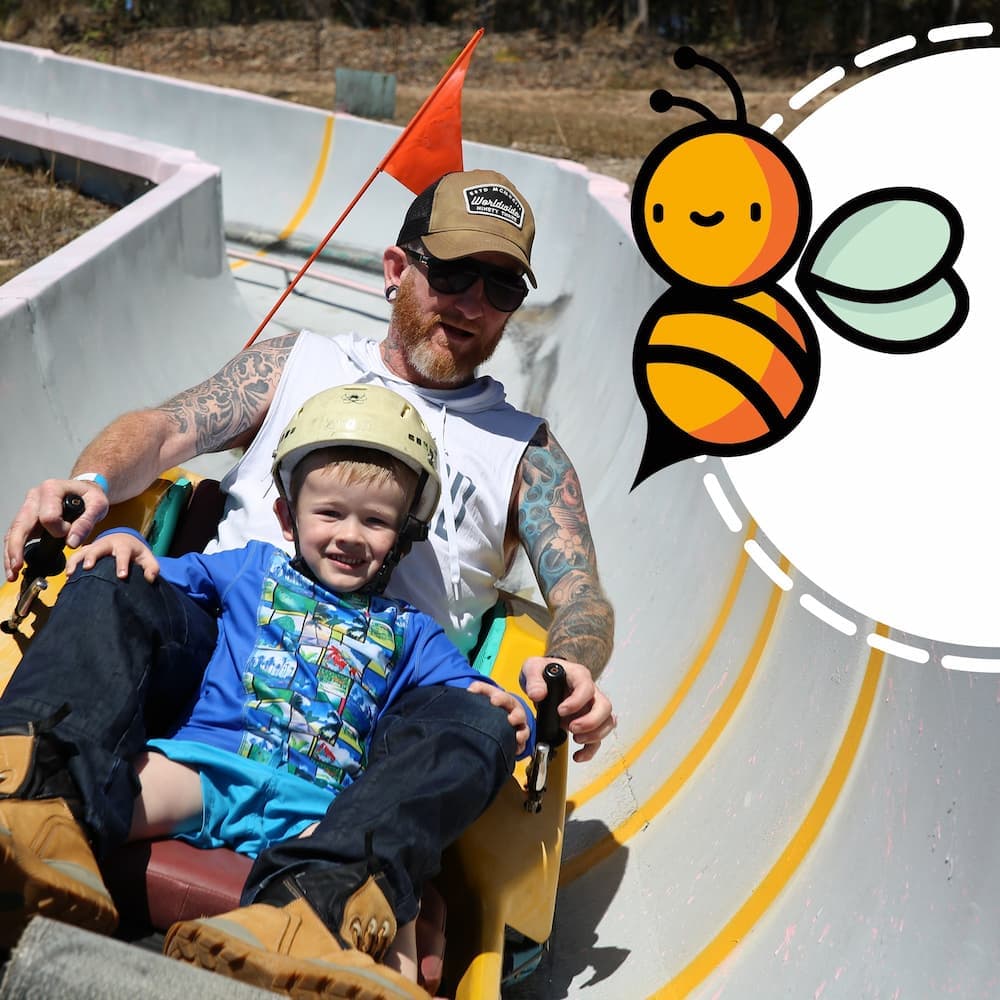 Father & Son Riding Toboggan In The Big Buzz Fun Park