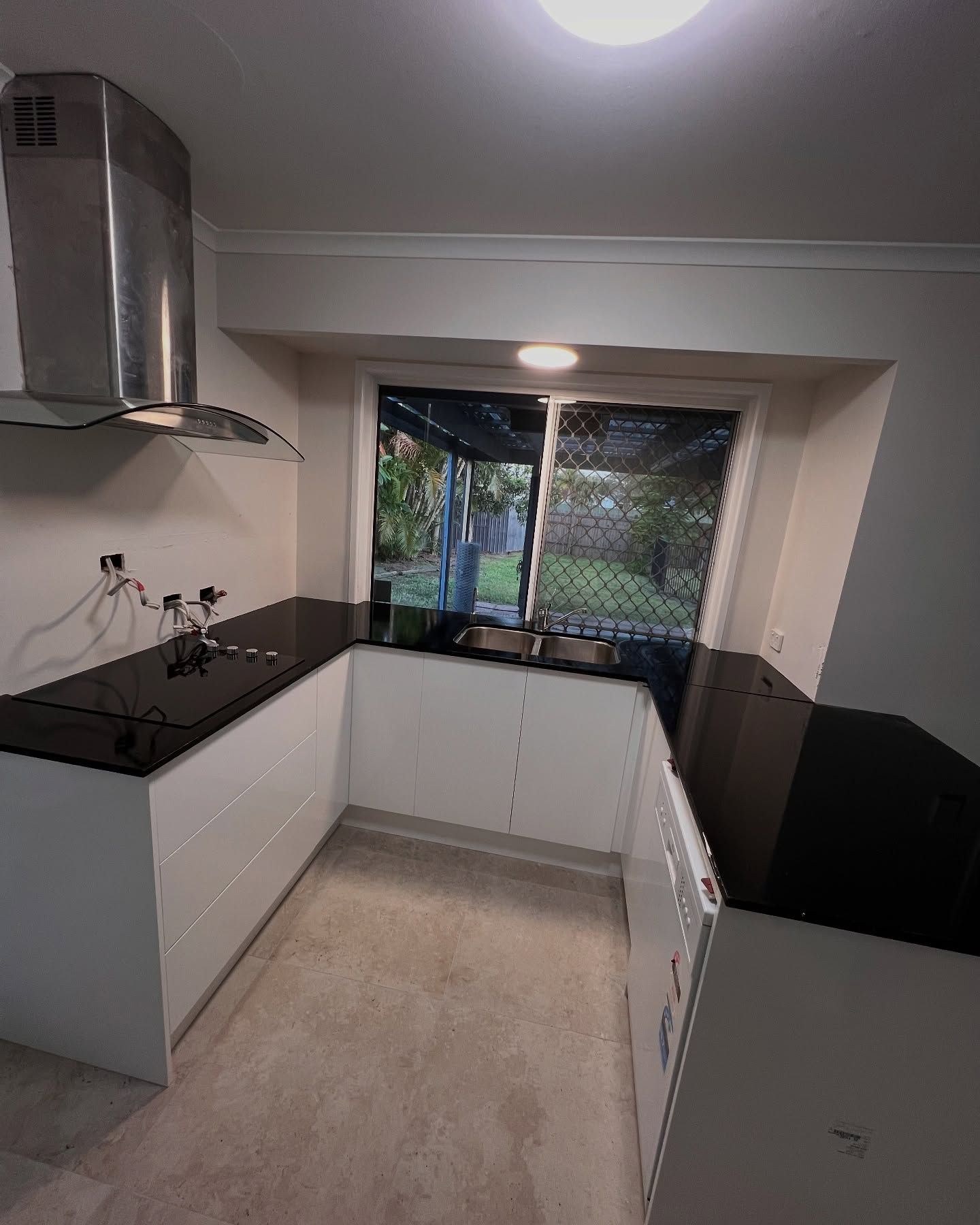 Modern White Kitchen With Black Countertops, Stainless Range Hood — Sunny State Carpentry and Joinery In Hope Island, QLD