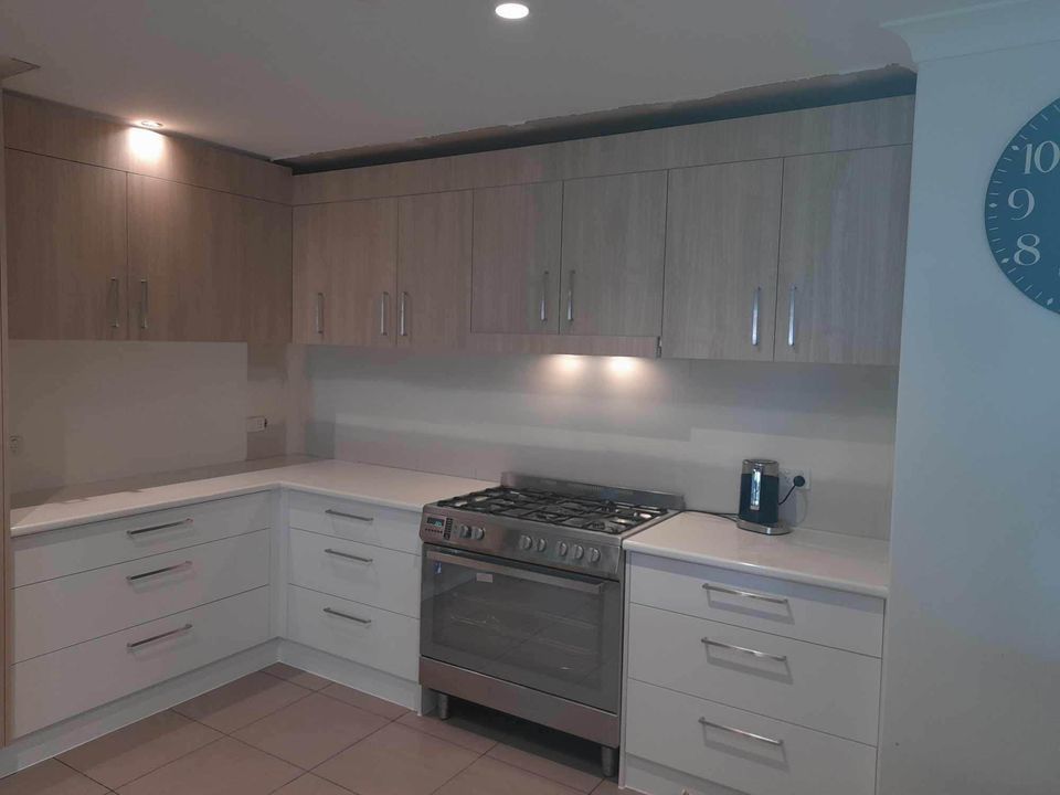 Modern White Kitchen With Light Wood Cabinets, a Gas Range — Sunny State Carpentry and Joinery In Hope Island, QLD