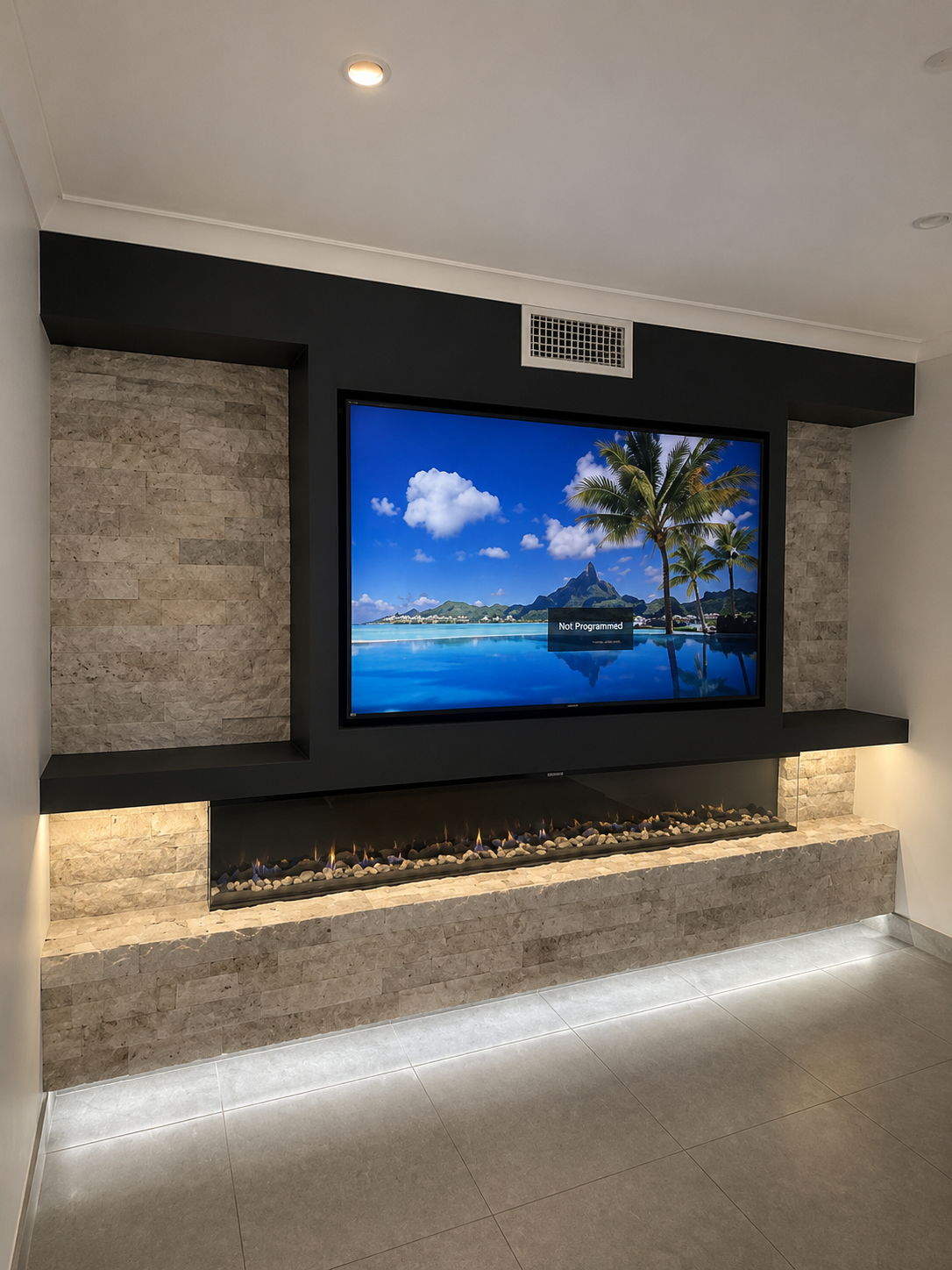 Modern living room with a wall-mounted TV above a stone fireplace and LED accent lighting