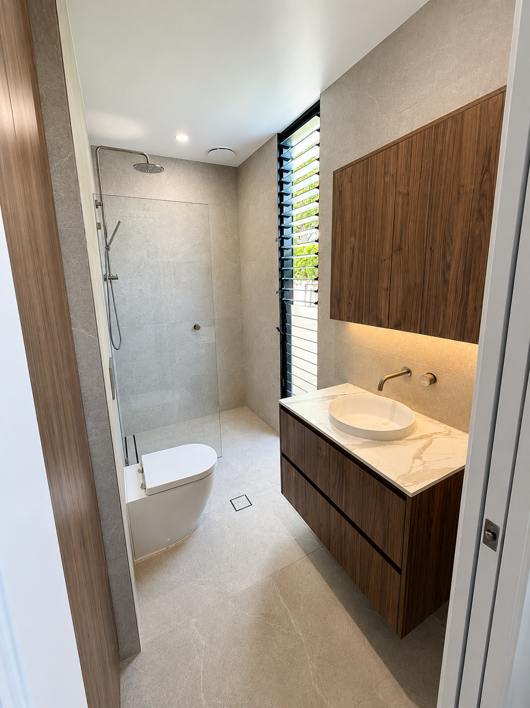 Modern bathroom with shower, floating vanity, round sink, and wood accents