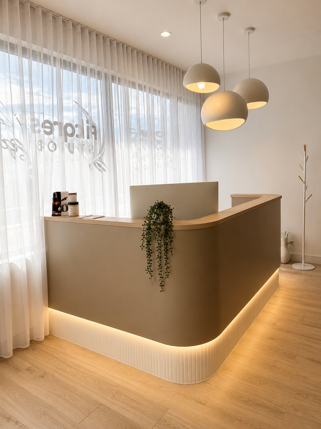 Modern minimalist reception desk in a bright white lobby with pendant lights and wood flooring