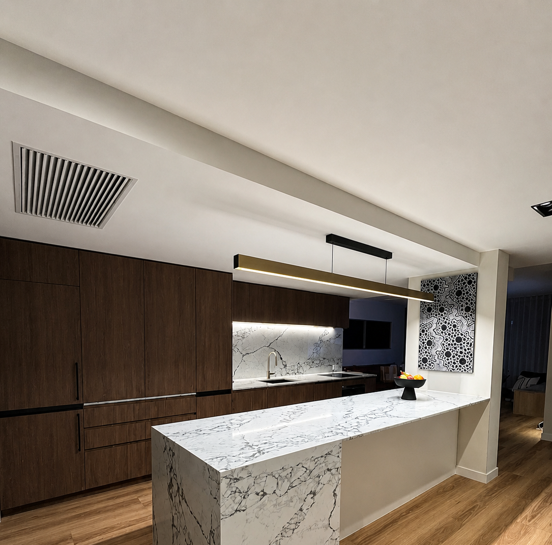 Modern kitchen with white marble island, dark wood cabinets, and pendant lighting
