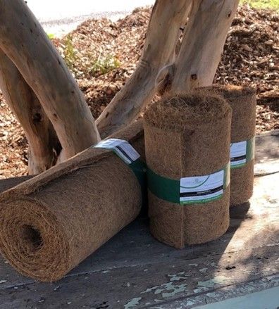 Three rolls of coconut fiber are sitting on a wooden table.