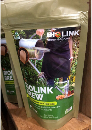 A bag of biolink brew tea is sitting on a wooden shelf.