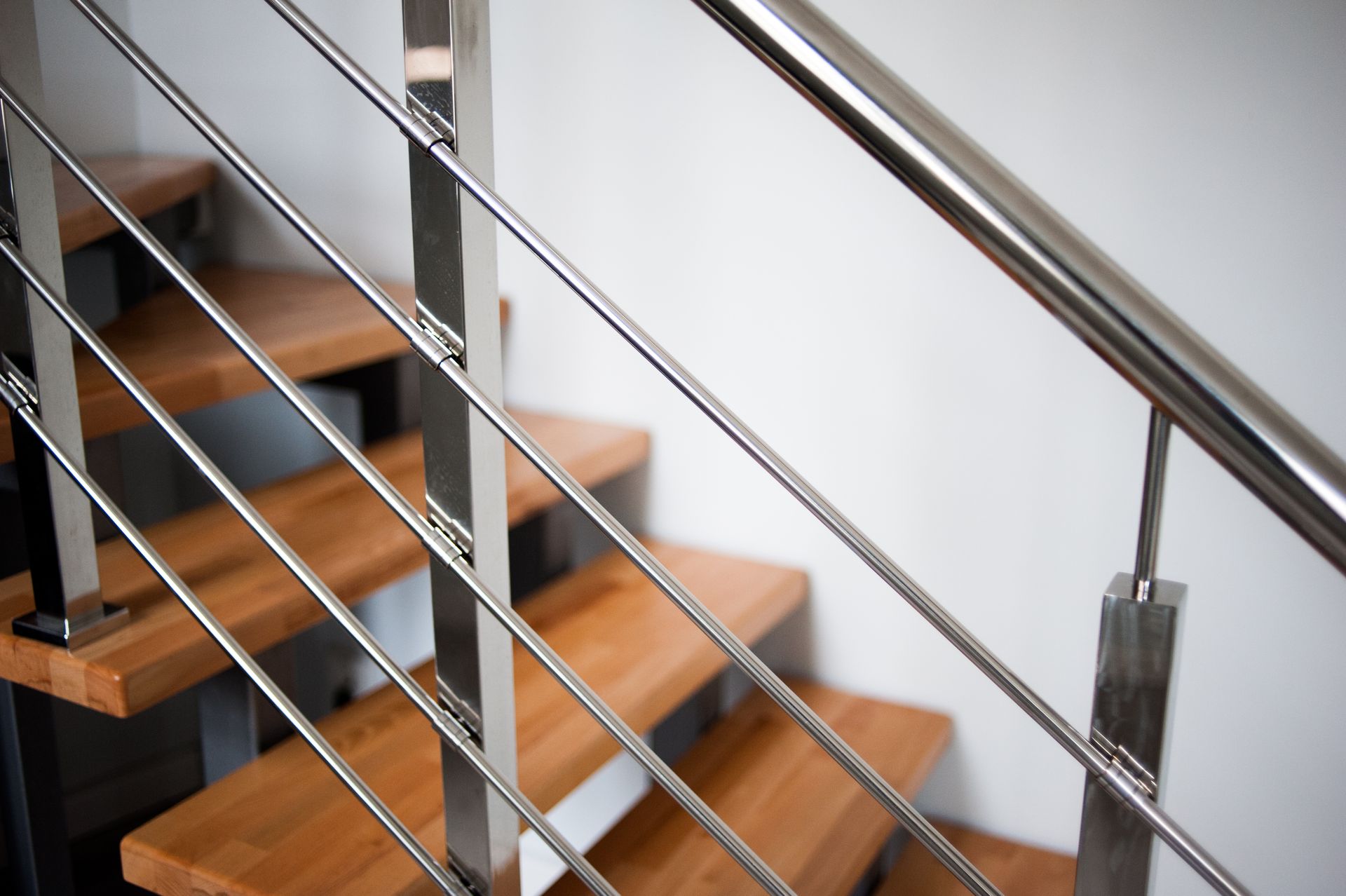 Wooden staircase with polished metal railings in an indoor setting