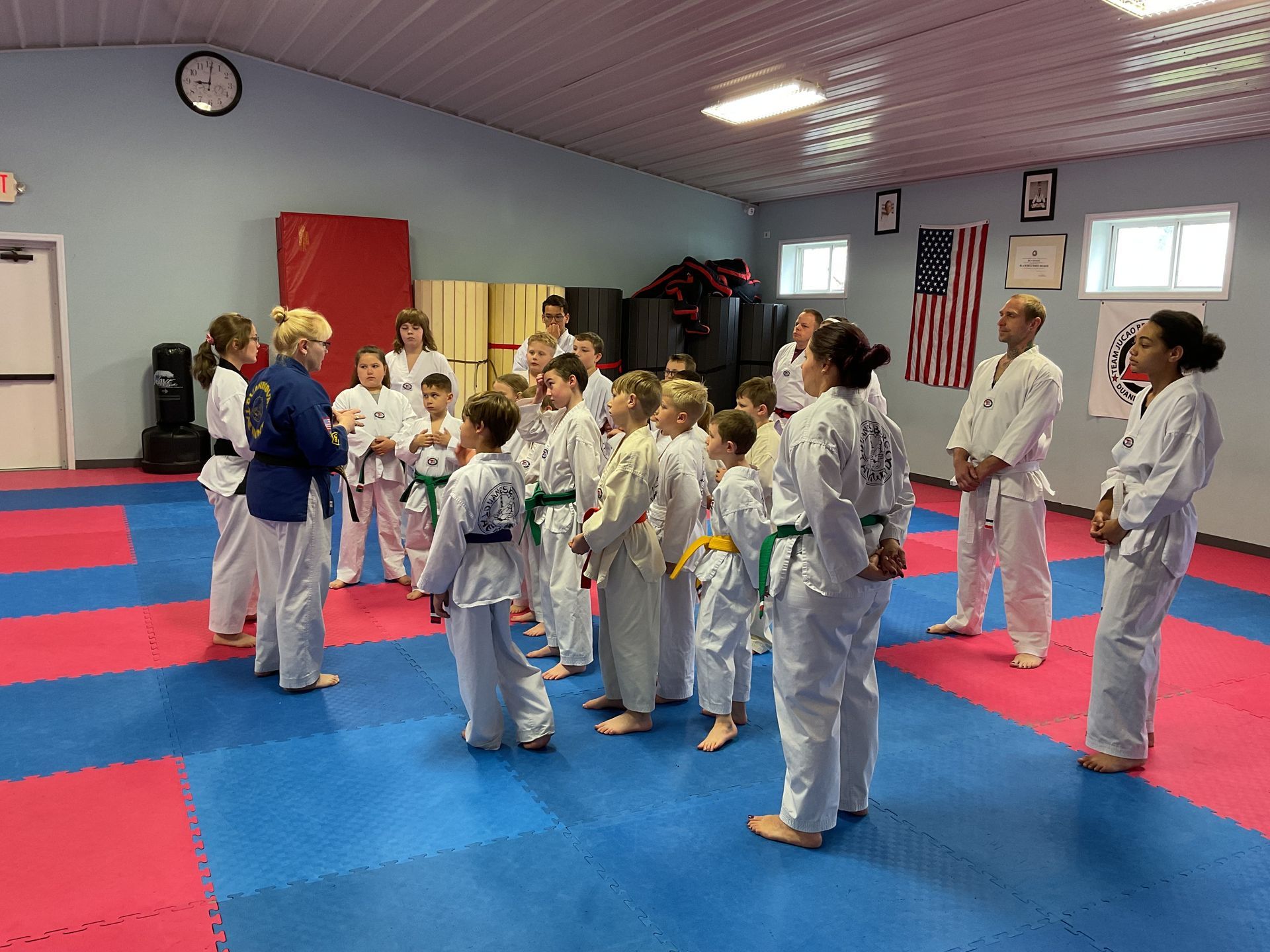 A group of people in karate uniforms are standing in a room.