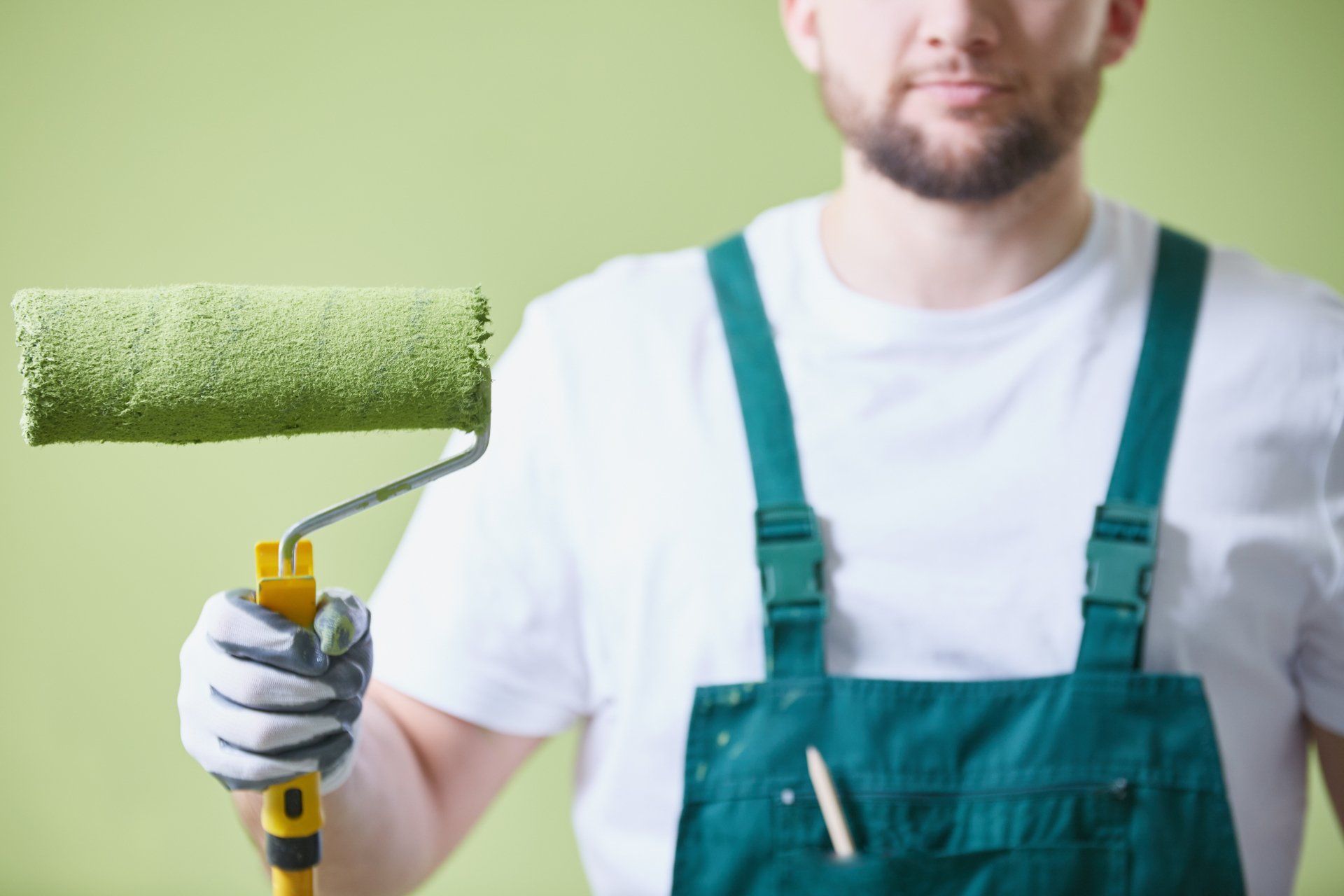 Painter in Peoria holding green roller