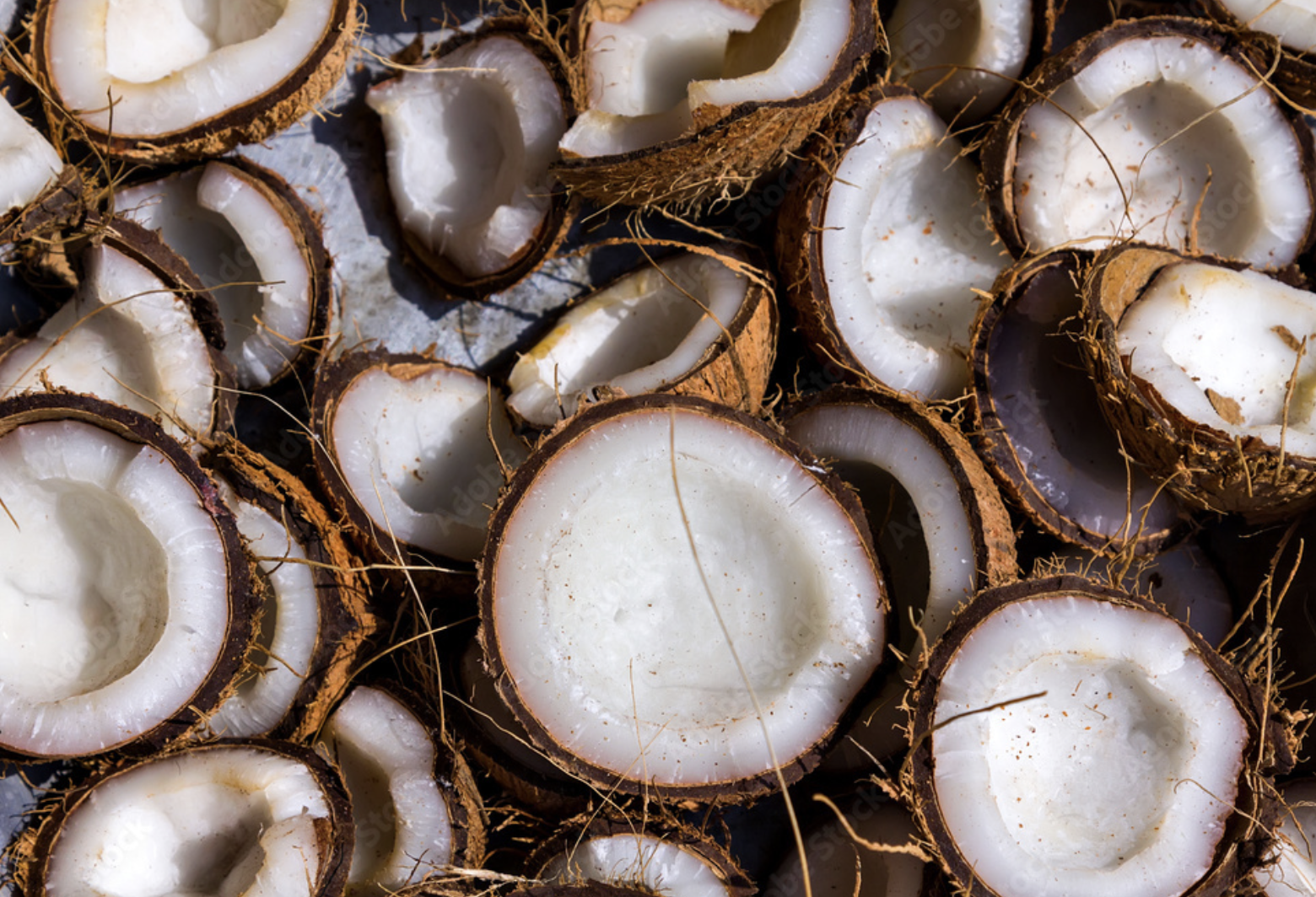 Un montón de cocos que han sido cortados por la mitad.