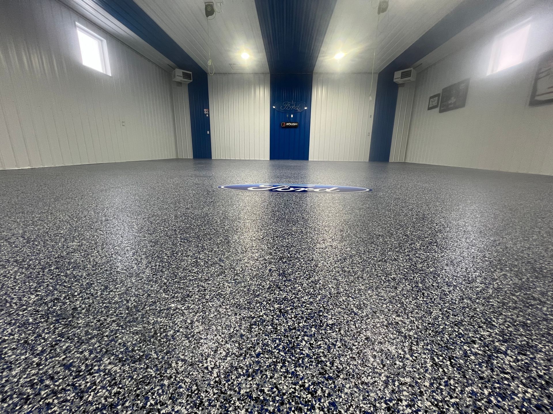A large room with a gray floor and a blue door.