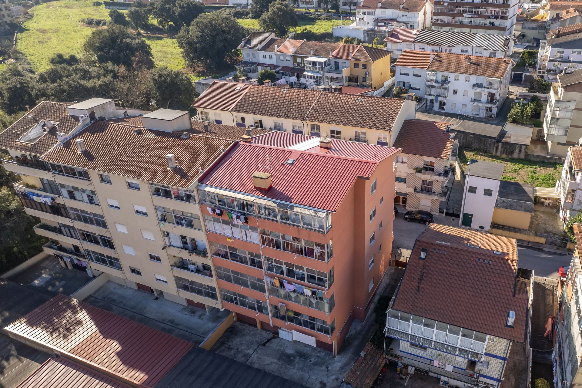 Vista aérea de prédios de apartamentos com telhados vermelhos e laranjas.
