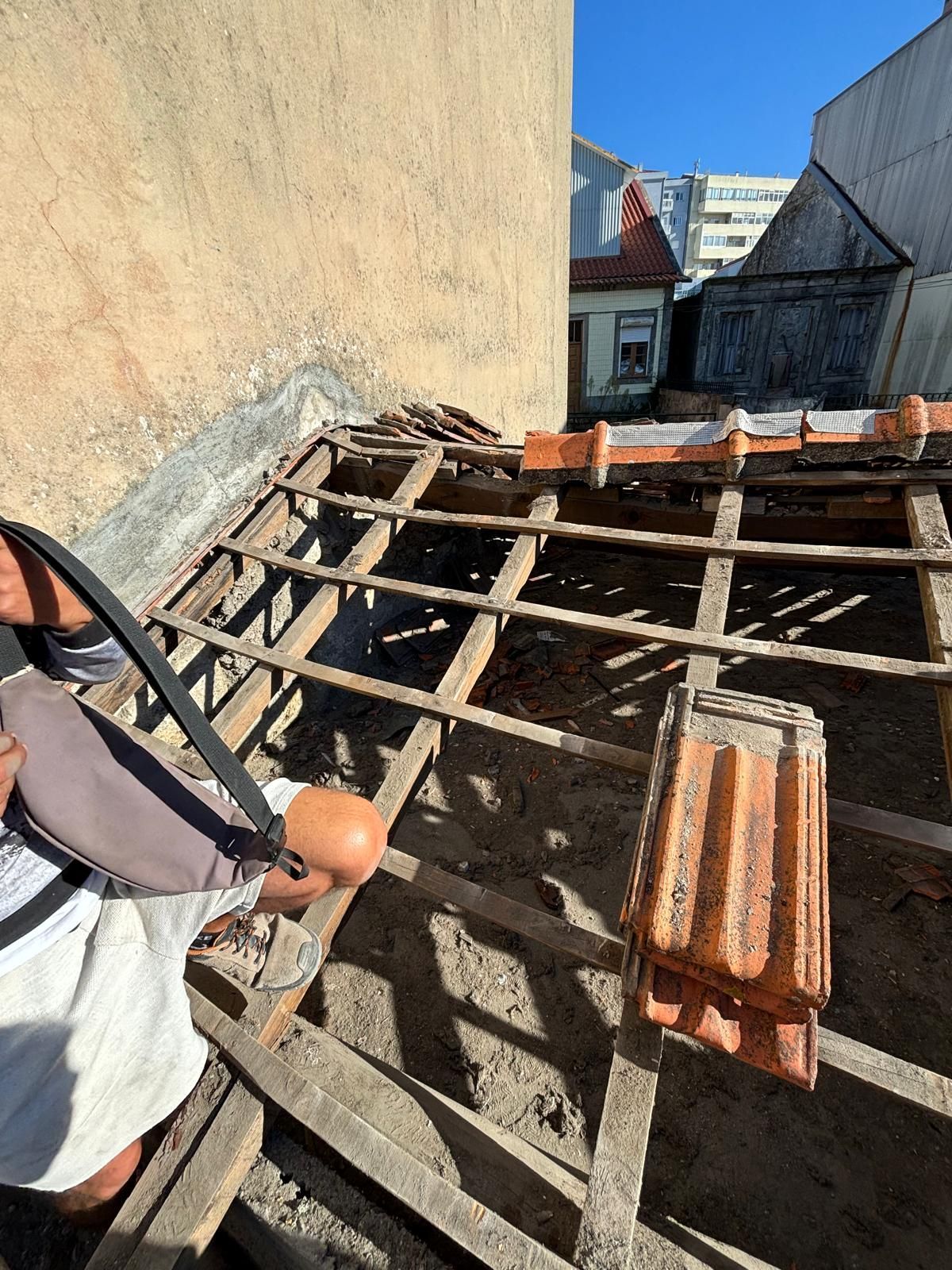Um homem está trabalhando em um telhado com um martelo.