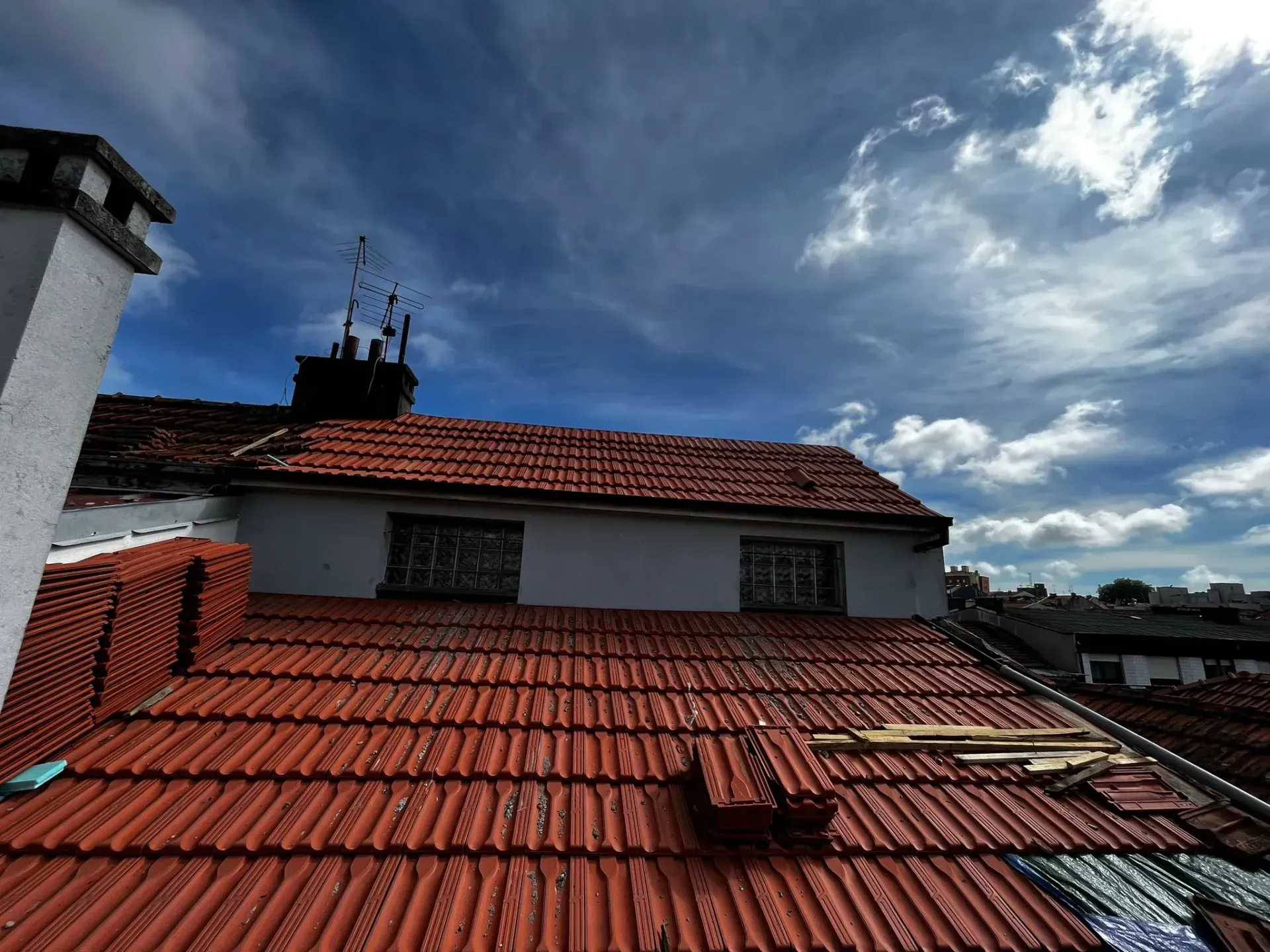 Um telhado de telhas com uma chaminé em cima