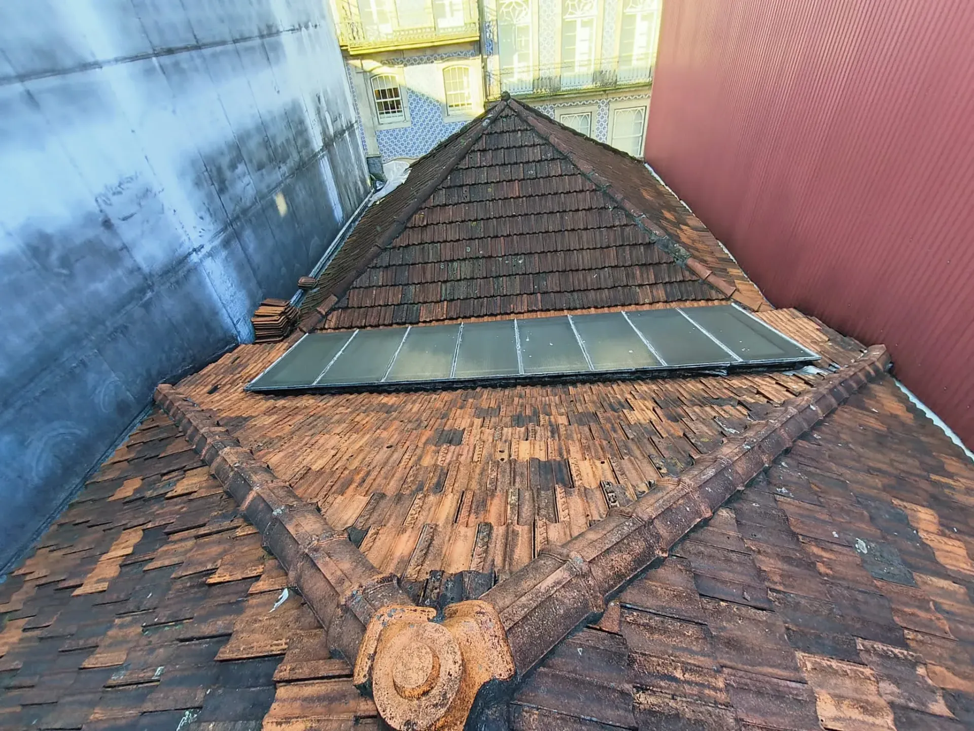 O telhado de um prédio é coberto de telhas e parece uma pirâmide.