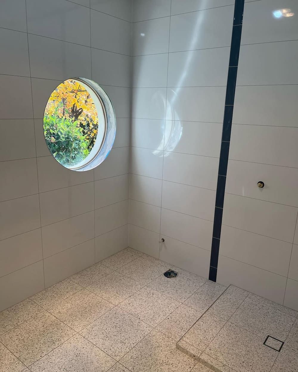 A Bathroom With a Round Window in the Wall — Canberra Bathroom Solutions in Ngunnawal, ACT