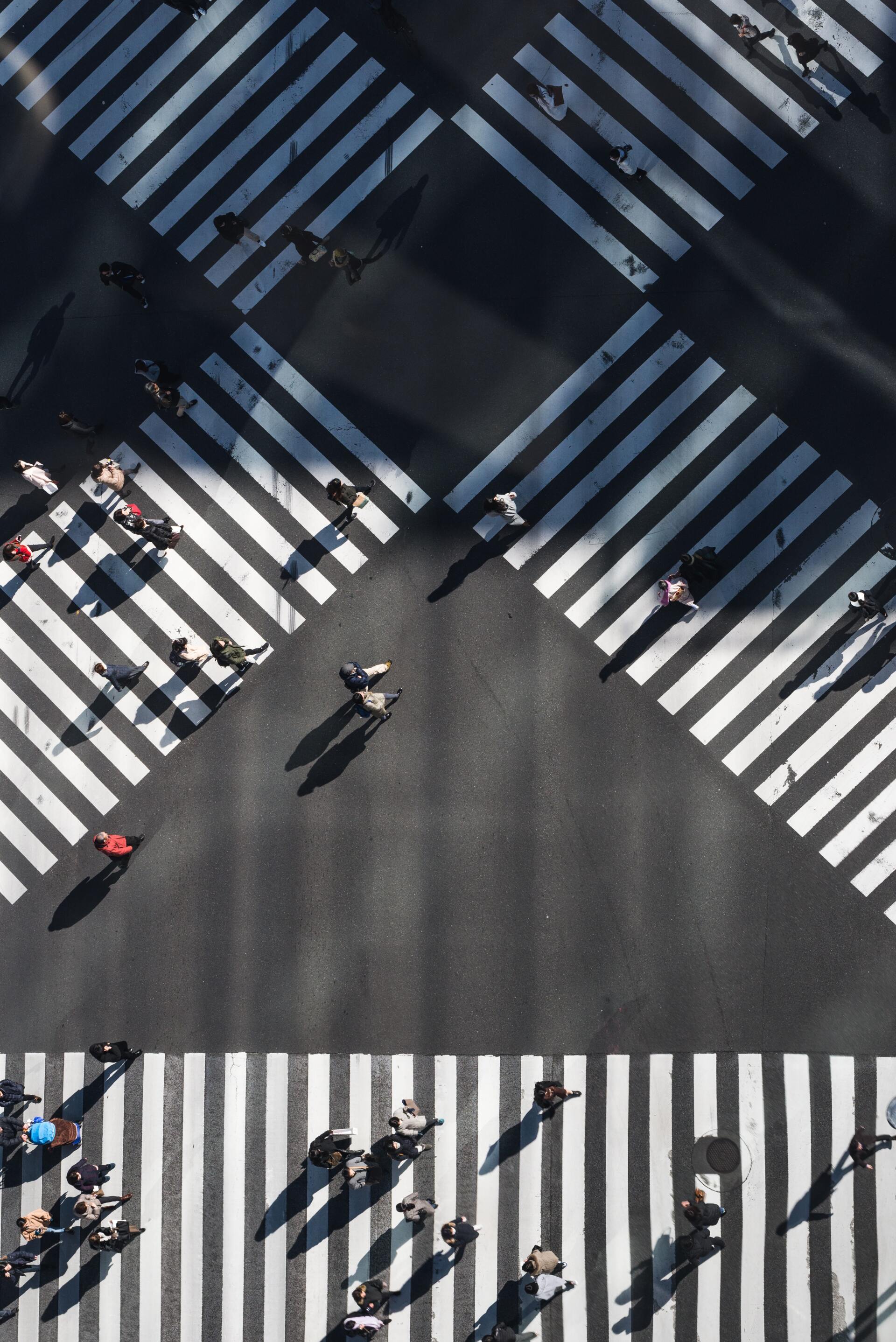 An aerial view of people crossing a crosswalk