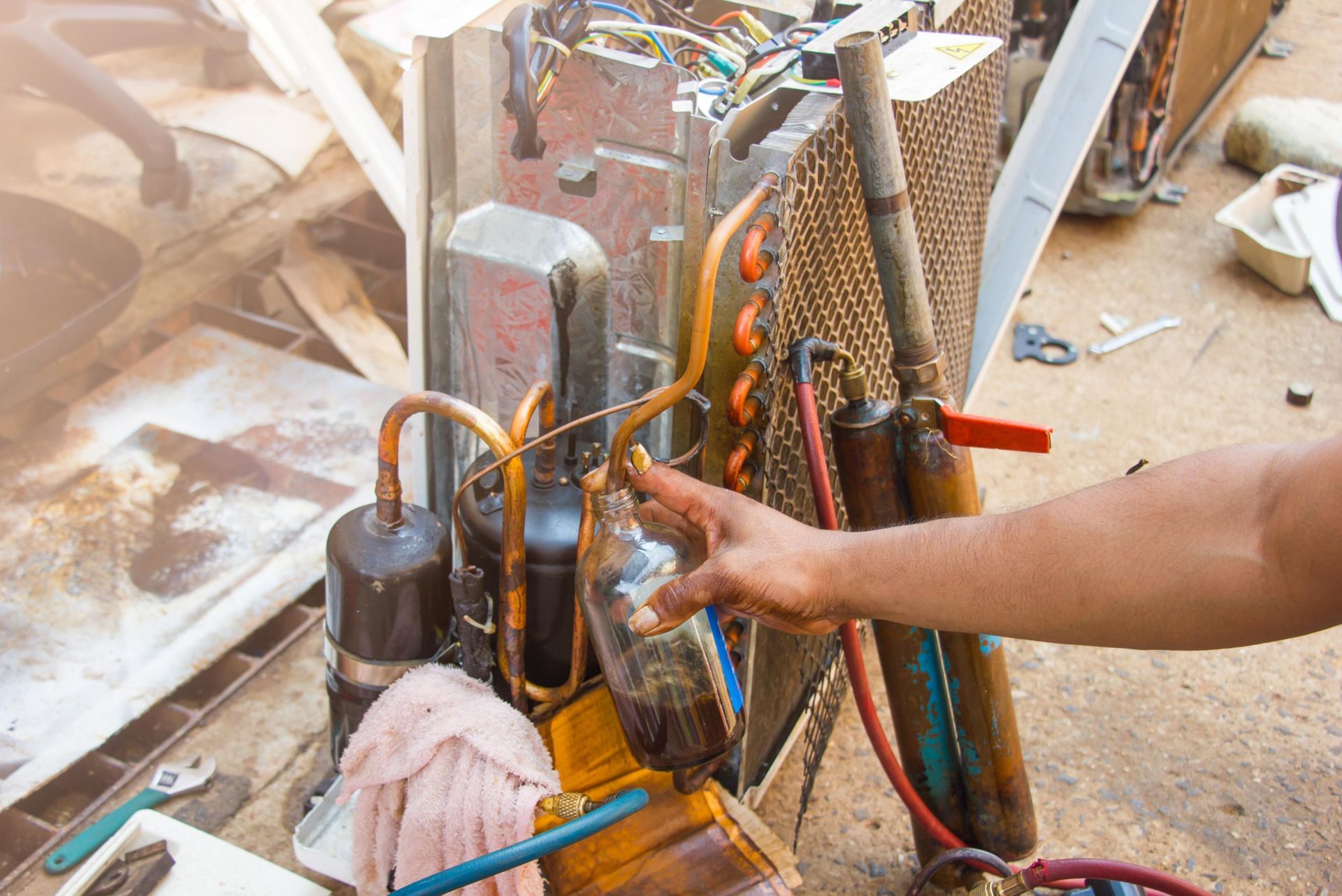 Person pointing at air conditioner components during repair.