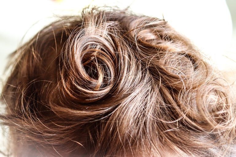 Close-up of light brown curly hair styled in a swirl on top of the head