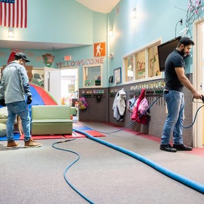 Two men are standing in a room with a sign that says yellowstone