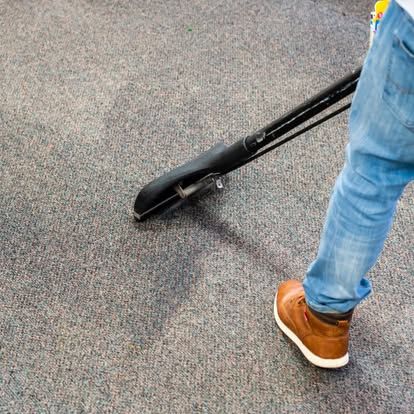 A vacuum cleaner is sitting on a carpet in a room.