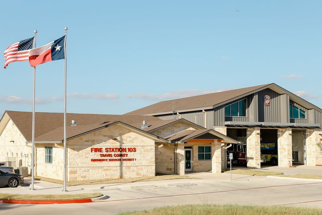 A fire station with two flags flying in front of it