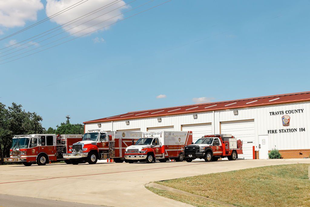 A row of fire trucks parked in front of a fire station