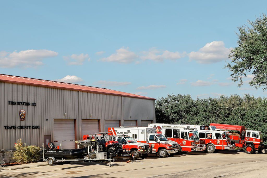 A row of fire trucks parked in front of a fire station