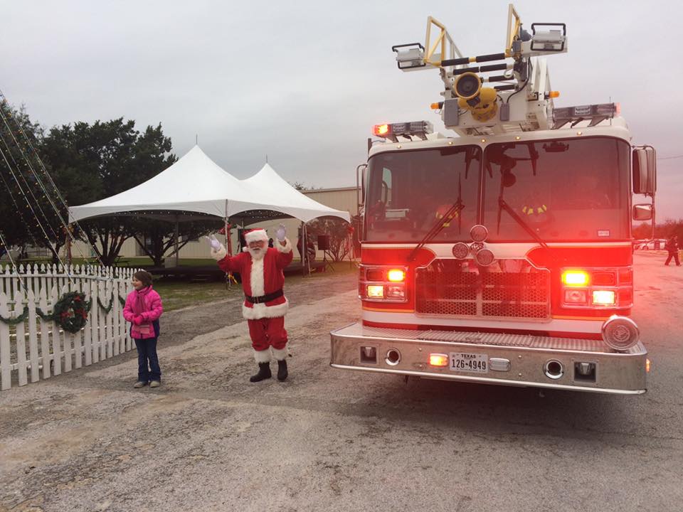 Santa claus is standing in front of a fire truck
