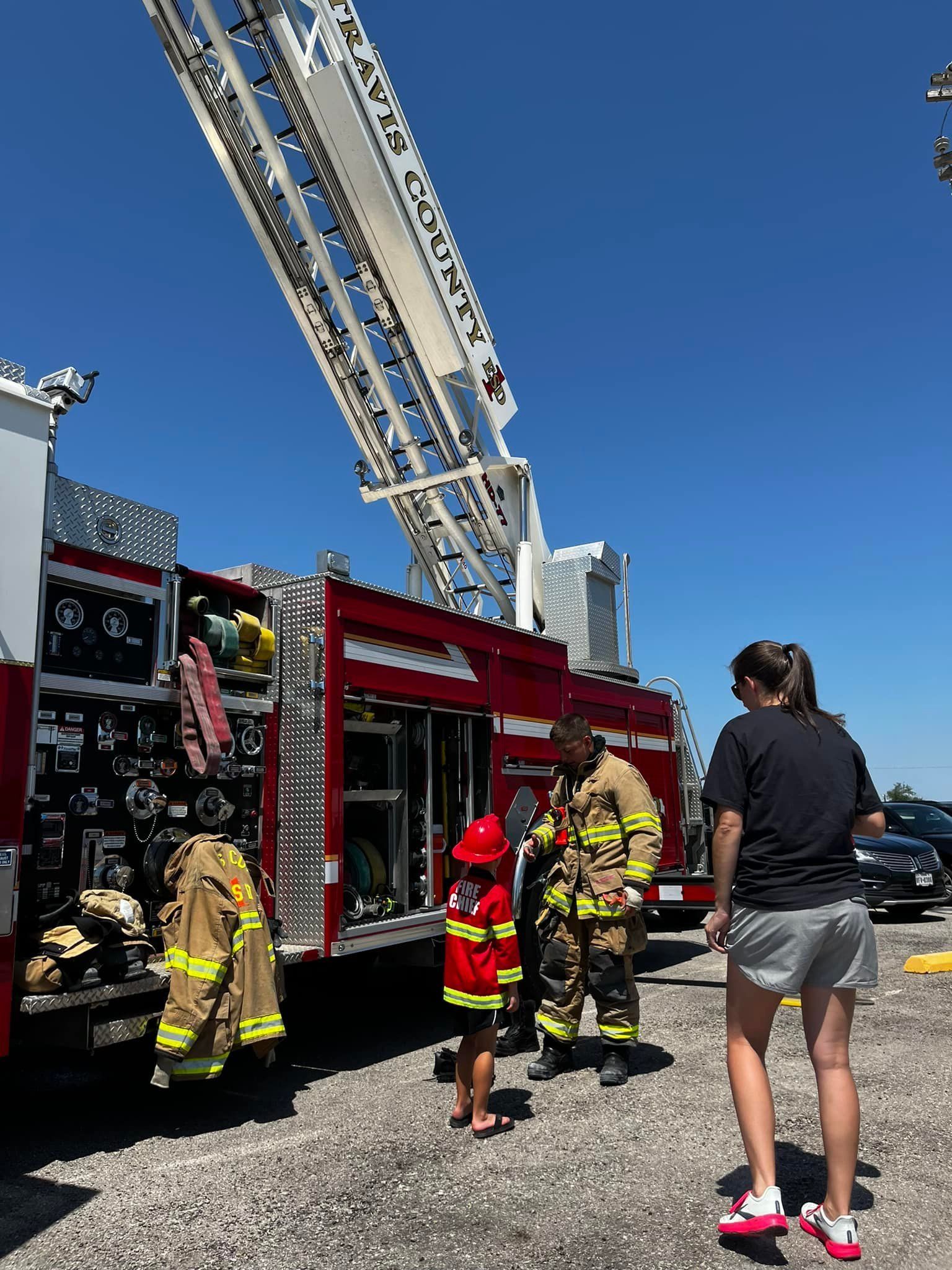 A group of people are standing in front of a fire truck.