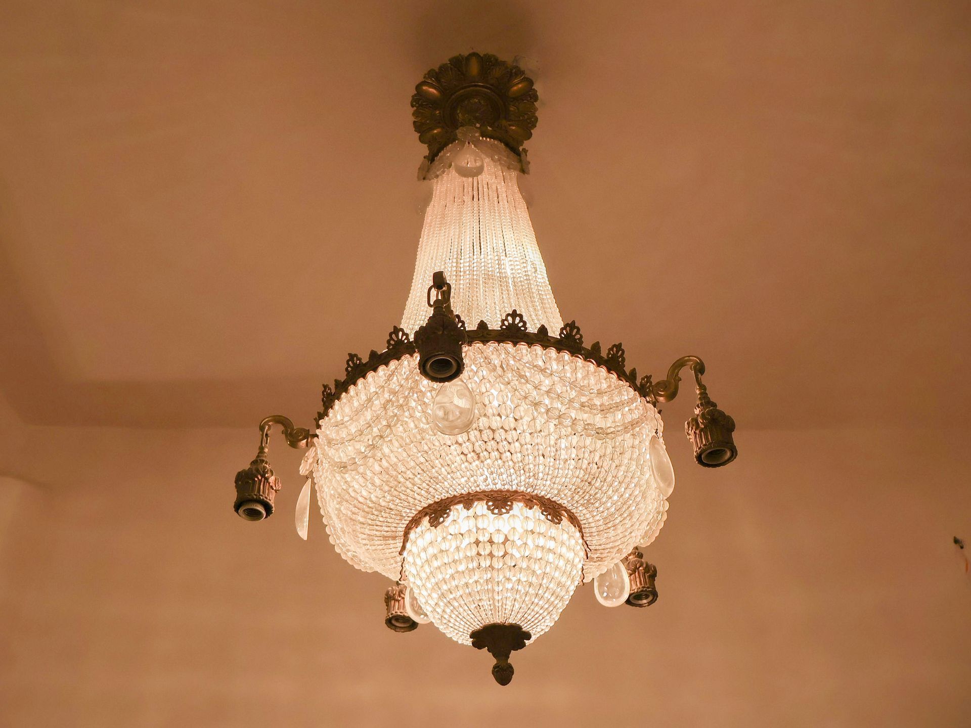 Ornate, crystal chandelier hanging from a light-colored ceiling.