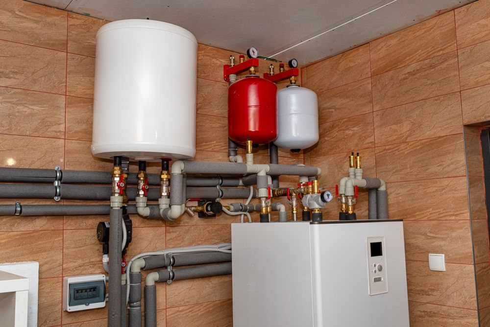 A room with a boiler and a water heater in it.