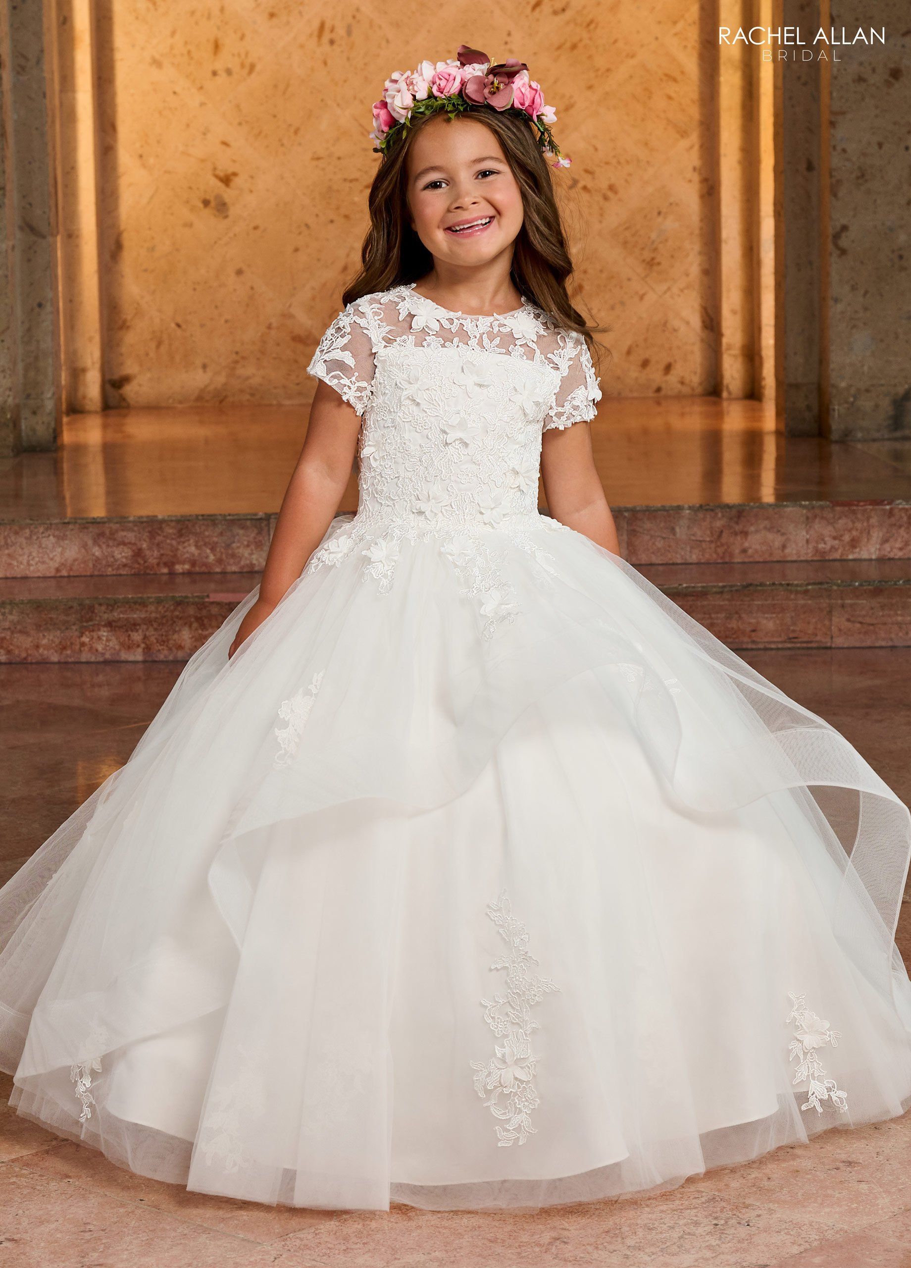 A  flower girl in a white dress with a flower in her hair