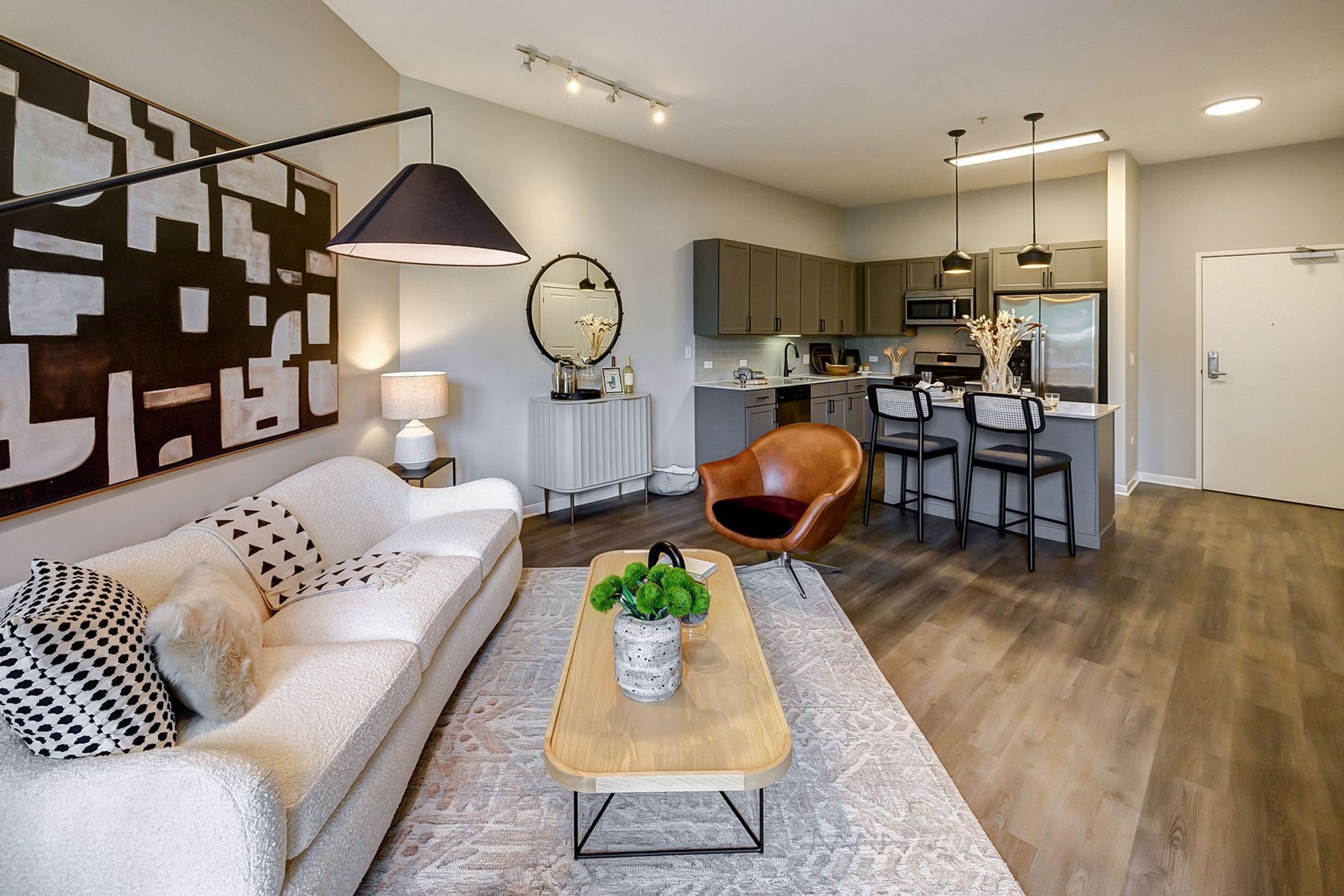 A living room with a couch , coffee table , chair and kitchen.