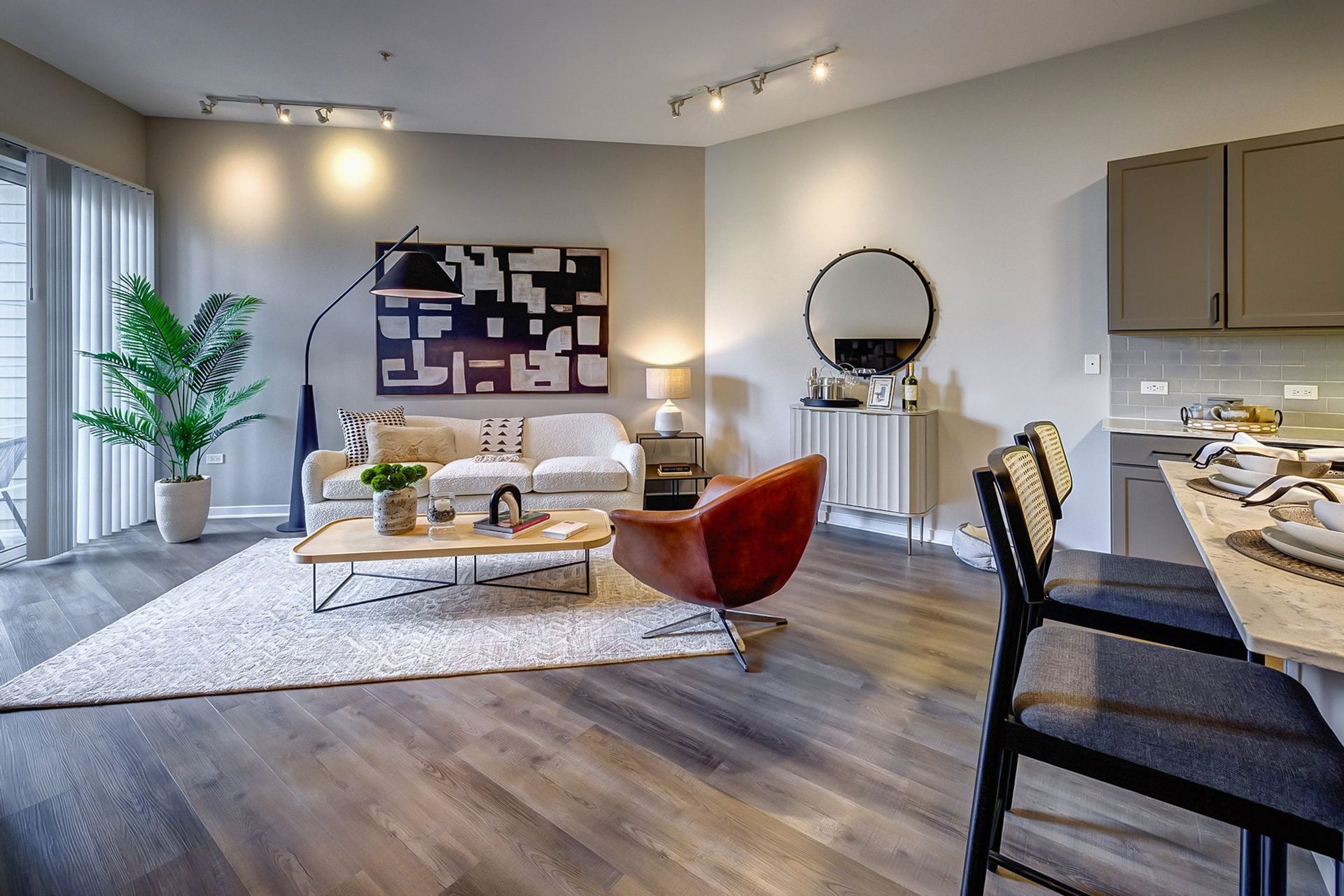 A living room with a couch , chair , coffee table , and stools.