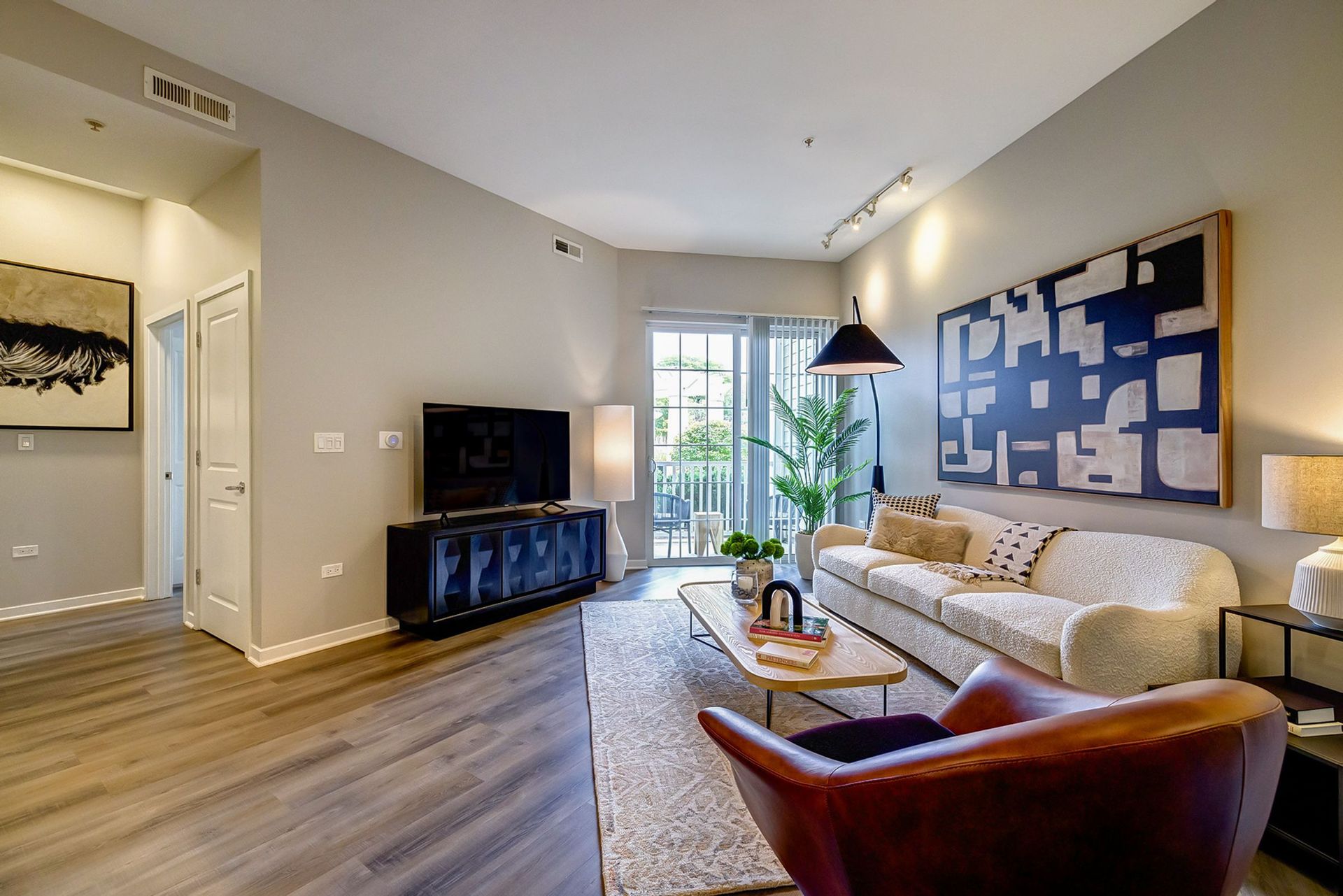 A living room with a couch , chair , coffee table and television.