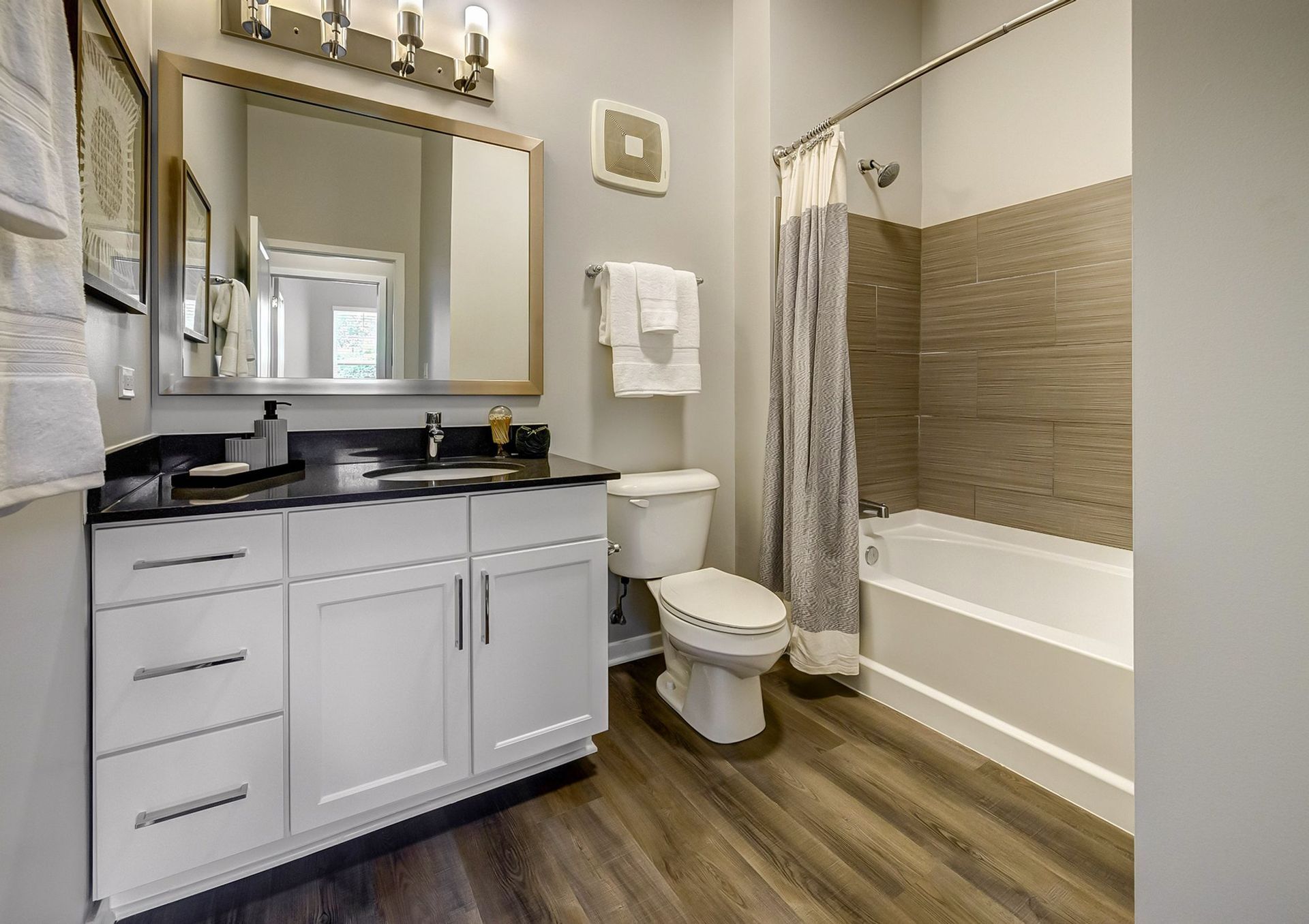 A bathroom with a toilet , sink , and bathtub.