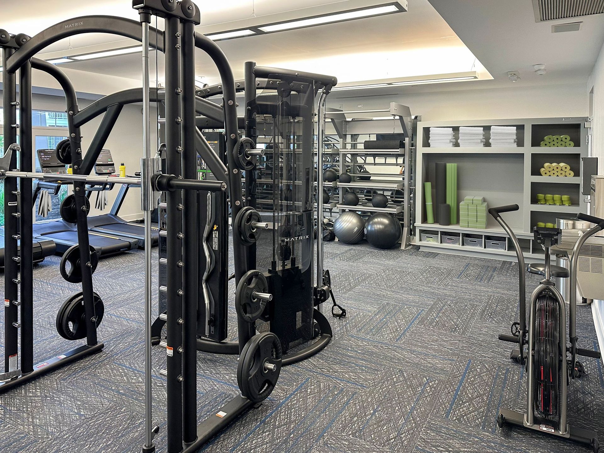 A large gym filled with lots of exercise equipment.