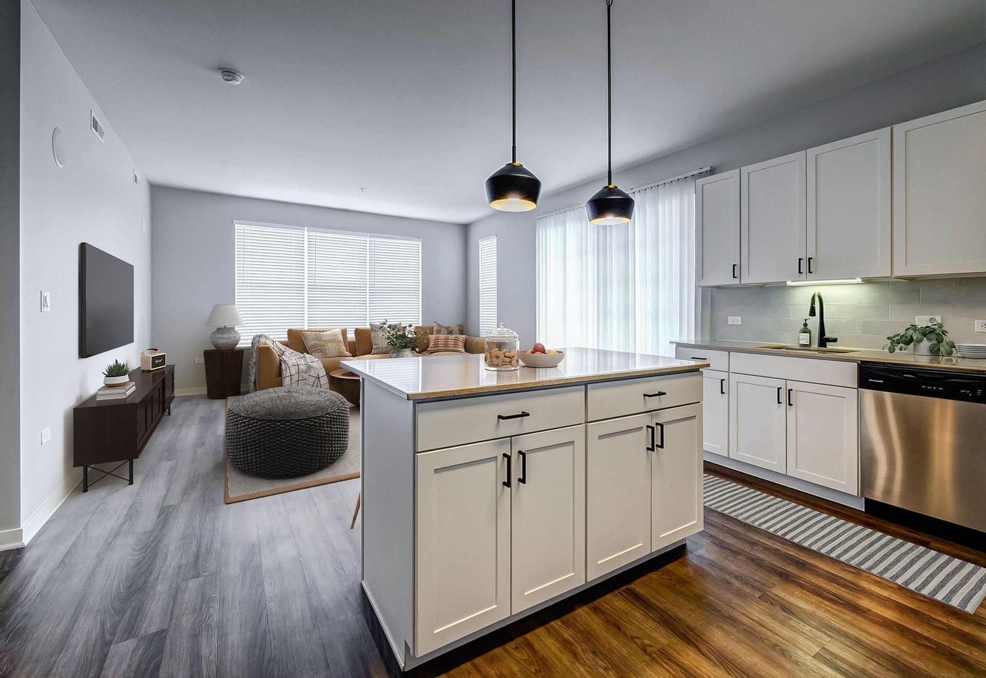 A kitchen with white cabinets and stainless steel appliances and a large island in the middle of the room.