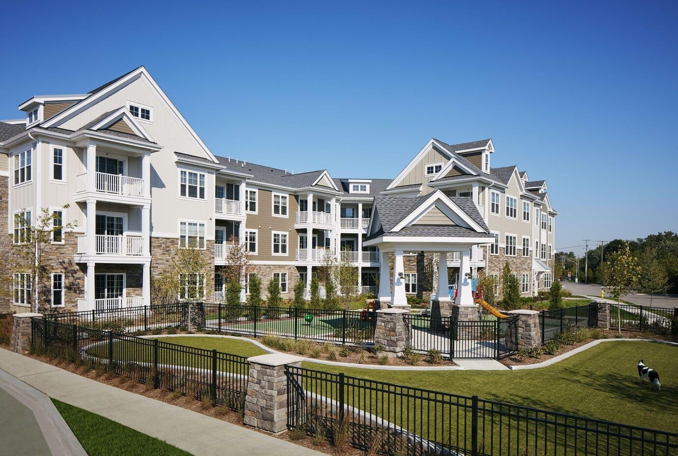 A large apartment building with a playground in front of it.