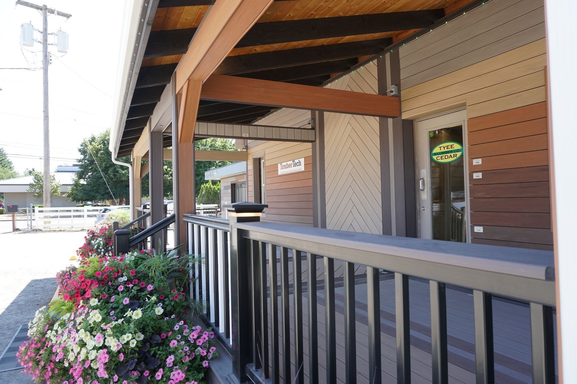 Building exterior with a wooden porch, flower boxes, and a shop entrance.
